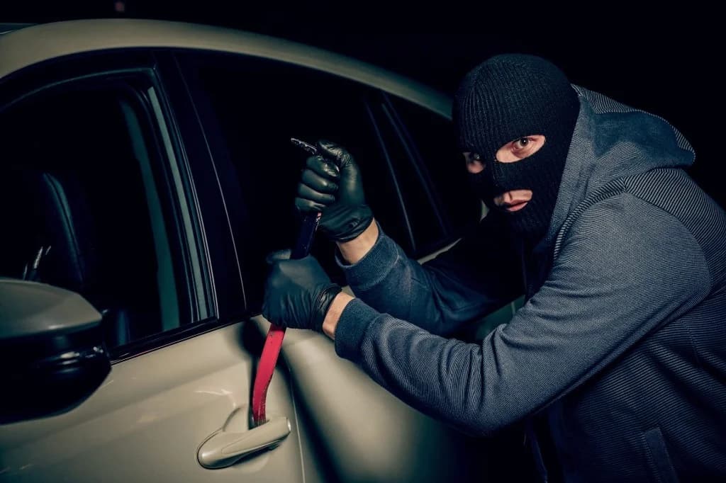 Krádež auta - zlodej sa pokúša vylámať vozidlo, dôvod prečo potrebujete ochranu vozidiel a autoalarm